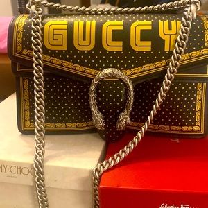 Guccy Dionysus Sega Letter, black and gold with silver chain.